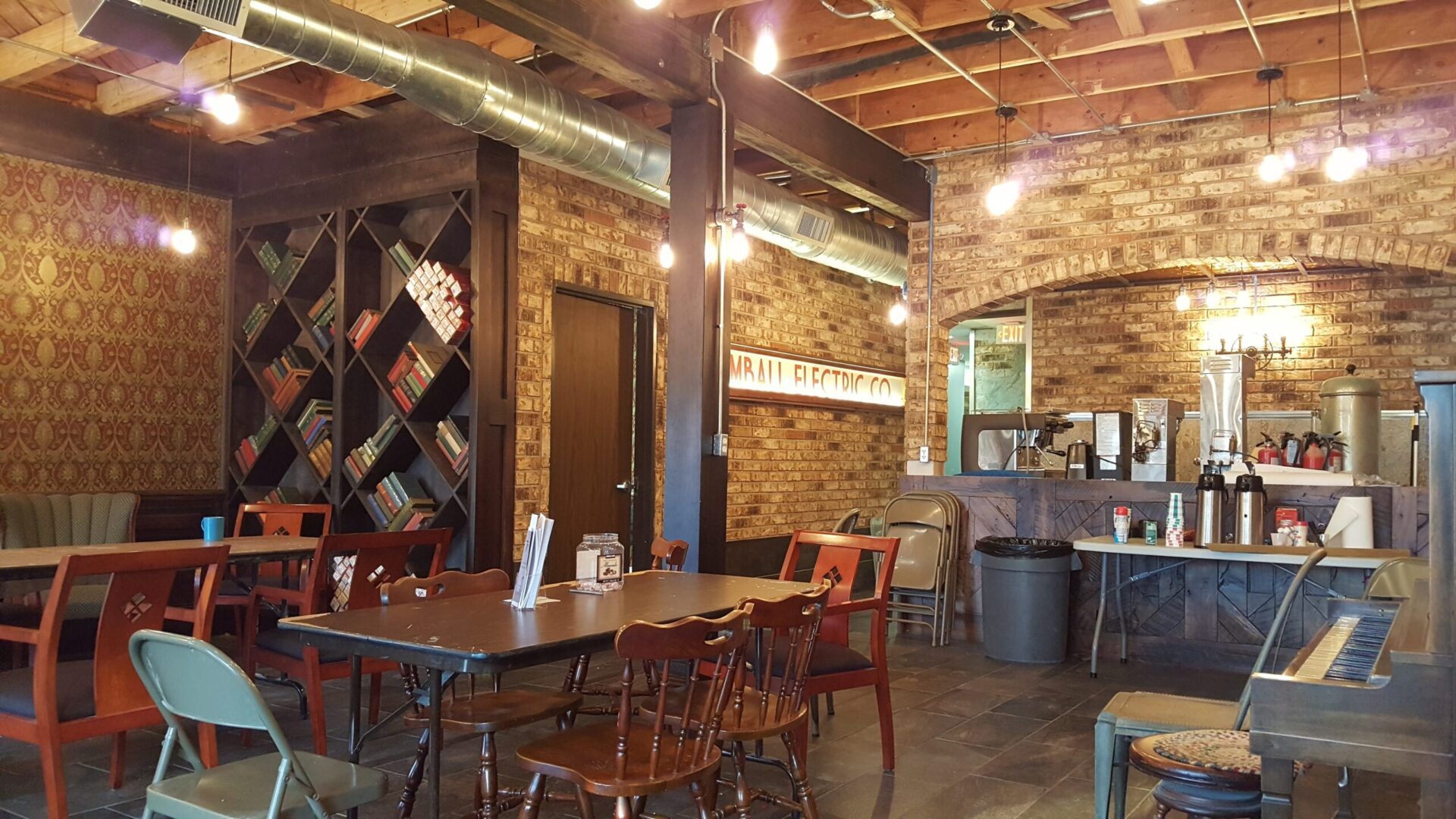 A restaurant with brick walls and wooden tables.