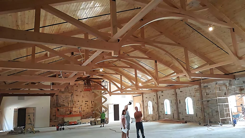 A group of people standing in an unfinished room.