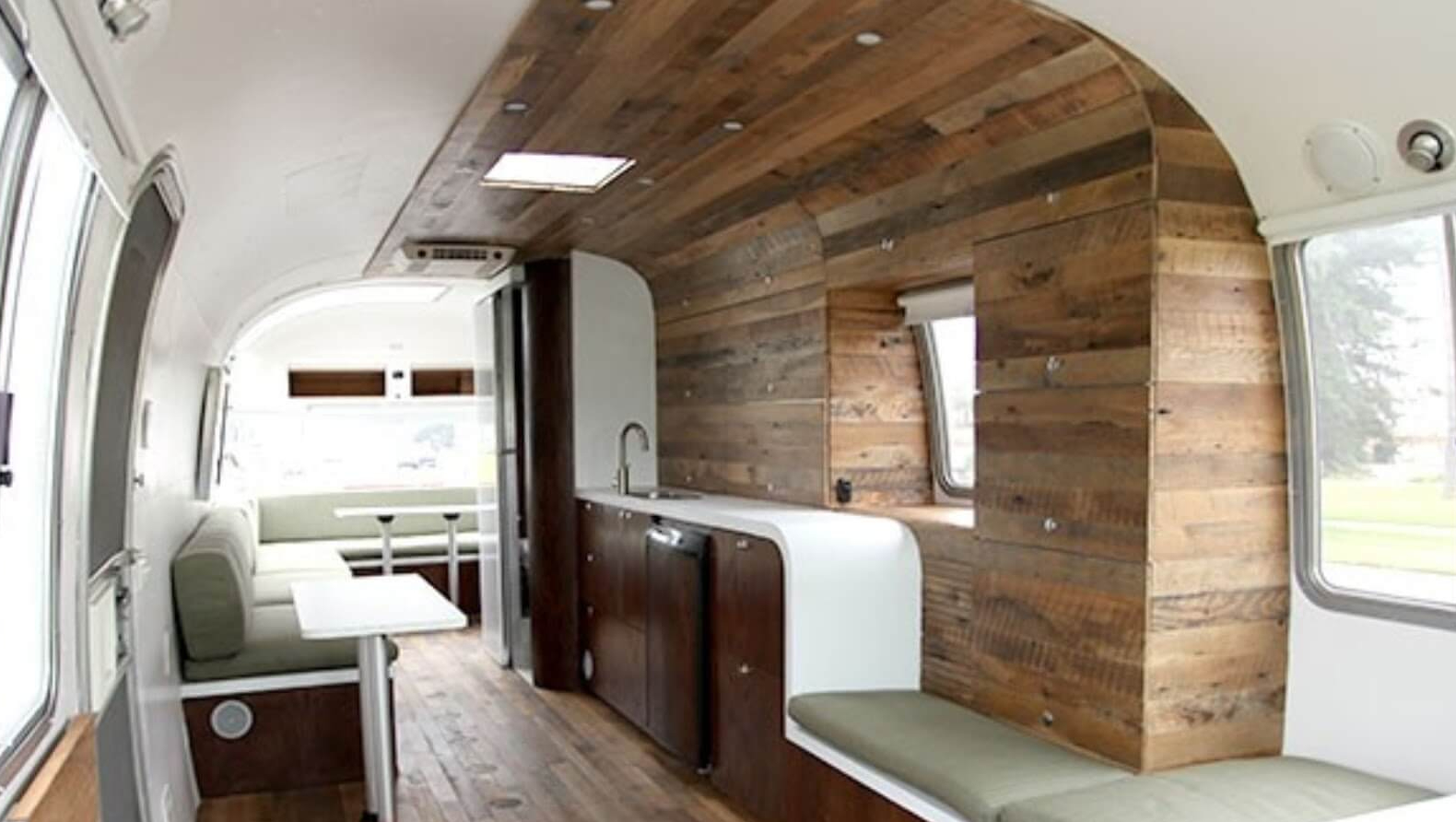 A kitchen with wood walls and white counters.